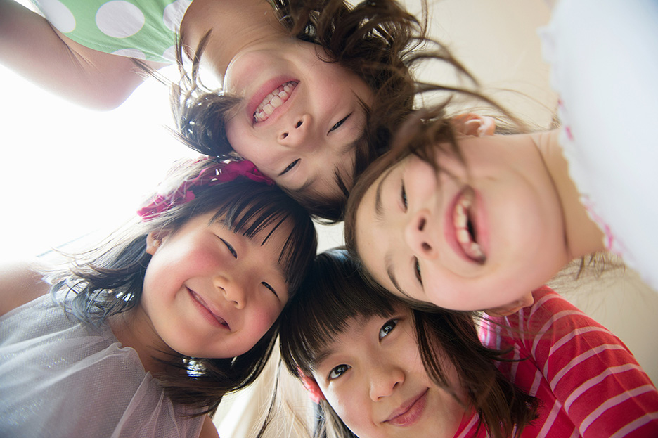 4人の女の子が笑顔で覗き込んでいる写真